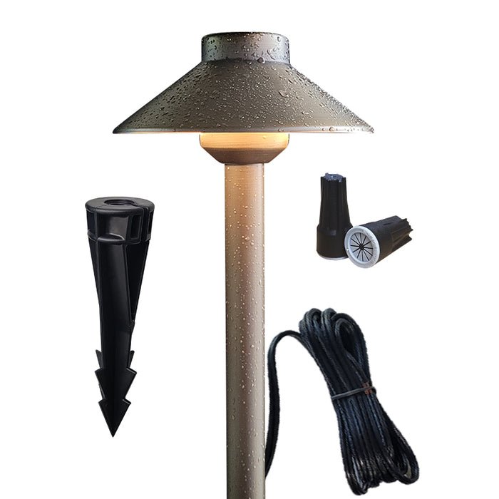 Brass path light set installed in outdoor landscape pathway
